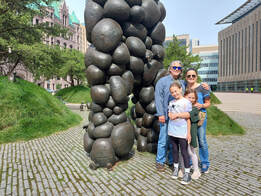 family of four posing in front of local art on a walking tour of Minneapolis